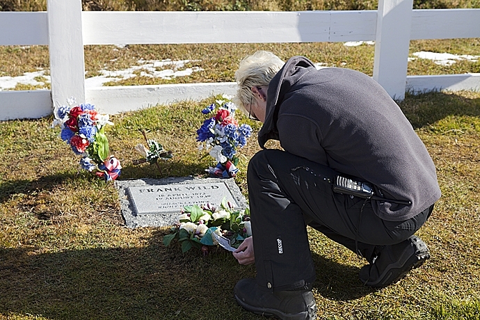 Tourist reads dedications to Frank Wild at his graveside in Grytviken, SOuth Georgia Island